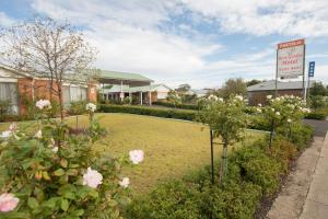 un cartello di fronte a un hotel con fiori di Rose Garden Motel a Geelong