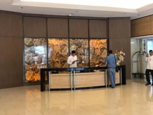 a group of people standing at a counter in a lobby at BEST Q CONDO w/ Great View in Manila