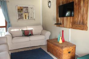 a living room with a couch and a tv at Shamba Yetu Mountain Lodge in Maanhaarrand