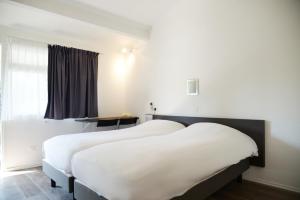 two beds in a hotel room with a window at Aerel Hotel Aéroport Blagnac in Blagnac +5 photos