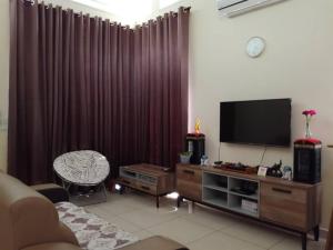 a living room with a flat screen tv and a chair at Kkp home stay in Alor Setar