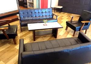 uma sala de estar com um sofá, uma mesa e cadeiras em Royal Inn Shinyamaguchi Ekimae em Yamaguchi