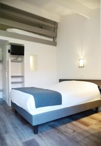 a bedroom with a large white bed and a flat screen tv at Aerel Hotel Aéroport Blagnac in Blagnac