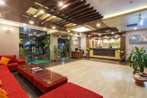 una hall con un divano rosso e un tavolo di Hotel Queens Park a Pokhara