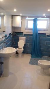baño con lavabo y aseo y ventana en Albergo Caprile, en Uscio