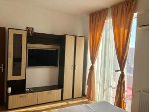 1 dormitorio con TV y ventana grande en Mamaia Nord, en Mamaia Nord – Năvodari