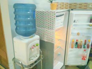 a water dispenser with a bottle on top of a refrigerator at Homestay Bumi Asri III Cikutra in Bandung
