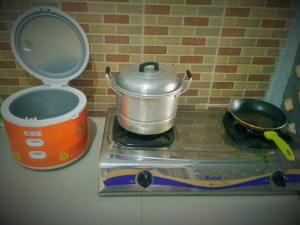 a pot sitting on top of a stove with a toaster at Homestay Bumi Asri III Cikutra in Bandung