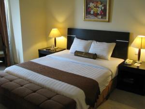 Grand Asia Hotel Jakarta tesisinde bir odada yatak veya yataklar