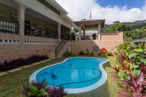 a swimming pool in the yard of a house at Beau Vallon Villa Chalets in Beau Vallon