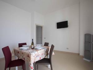a dining room table with a bottle of wine and chairs at Cala Del Faro Beach Villas in Cittadella del Capo