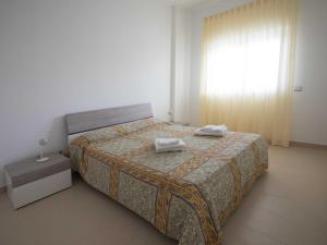 a bedroom with a bed with two towels on it at Cala Del Faro Beach Villas in Cittadella del Capo