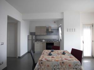 a kitchen with a table with a table cloth on it at Cala Del Faro Beach Villas in Cittadella del Capo