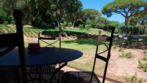 a table and chairs with a view of a park at Les Pins de l'Escalet in Ramatuelle