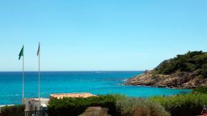 a view of the ocean with a flag on a building at Les Pins de l'Escalet in Ramatuelle