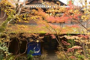 a house with autumn leaves on the side of it at Sanso Tensui in Hita