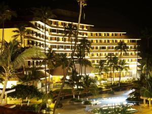 vista di un hotel di notte con palme di The Retreat Hotel & Convention Centre a Mumbai