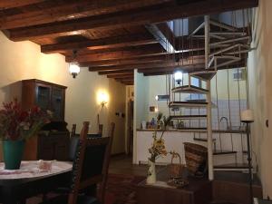 Una sala de estar con una mesa y una escalera de caracol. en Appartamento delle Erbe, en Padua