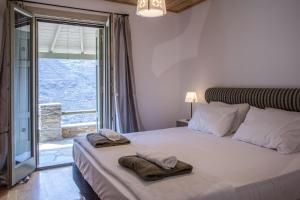 a bedroom with a large bed with towels on it at Anastasis Luxury Villa Andros With Heated Pool in Sinétion +26 photos
