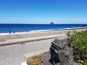 una pared de piedra junto a una playa con el océano en Stromboli Vacanze en Stromboli