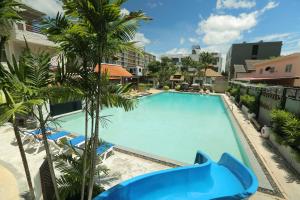 an overhead view of a large swimming pool with palm trees at My Way Hua Hin Music Hotel SHA Extra Plus in Hua Hin