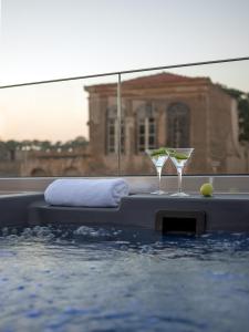 una piscina con dos copas de martini sentadas encima en Mediterraneo Suite Home, en Rethymno