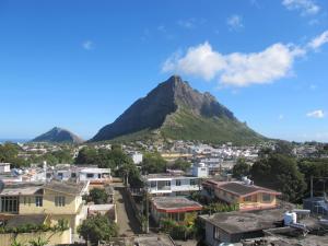 a view of a city with a mountain in the background at Auberge Le Rajah in Quatre Bornes