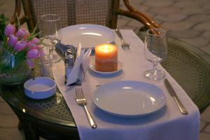 a table with a candle and plates and glasses on it at Пансионат Мармелад Иссык-куль in Bosteri