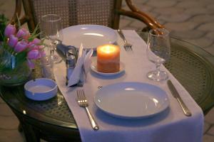 a table with a candle and plates and glasses on it at Отель Мармелад Иссык-куль in Bosteri
