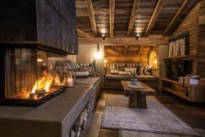 a living room with a fireplace and a couch at BelArosa Suiten & Wellness in Arosa