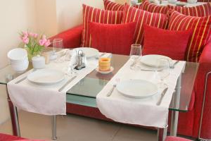 a table with plates and wine glasses and a red couch at Отель Мармелад Иссык-куль in Bosteri