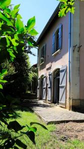 - un bâtiment avec une porte et une pelouse dans l'établissement l'ancienne gare, à Gamarde-les-Bains