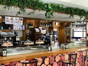 a restaurant with a counter with a bar with chairs at Hostal Puerta La Villa in Tordesillas
