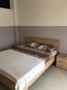 a bedroom with a wooden bed and a table at Apartments Flamida in Ulcinj