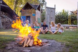 Eine Gruppe von Menschen, die um ein Feuer herum sitzen in der Unterkunft Ferienwohnungen Sonnengarten in Gunzenhausen