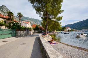 a group of people sitting on the side of a river at Apartment Iv in Kotor