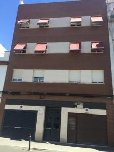 un edificio alto de color marrón con dos puertas y ventanas de garaje en Habitaciones Dulces Sueños, en Córdoba