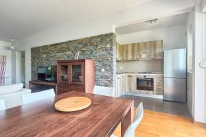 a kitchen with a wooden table and a refrigerator at Apartment Genco in Peroj