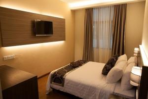 a hotel room with a bed and a tv on the wall at Holiday Villa Hotel & Suites Kota Bharu - Wakaf Che Yeh, Night Market in Kota Bharu