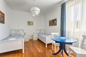 a bedroom with two beds and a blue table at Apartment Genco in Peroj