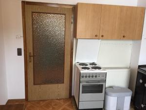 a small kitchen with a stove and a door at Amstetter’s Ferienwohnung in Waldenstein +13 photos