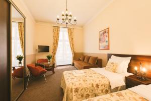 um quarto de hotel com uma cama e uma cadeira em Abella Suites & Apartments by Artery Hotels em Cracóvia