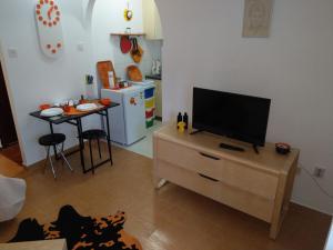 a living room with a television on a dresser with a table at AS Apartments Risan in Risan