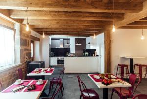 two tables and chairs in a room with a kitchen at Hotel Rural Pinares de Soria in Molinos de Duero