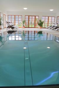 ein großer Pool mit Stühlen in einem Gebäude in der Unterkunft Hotel Hochsteg Gütl | Traunsee Salzkammergut in Ebensee