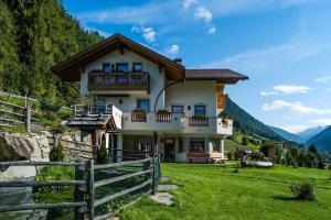 a house on a hill with a fence in a field at Alpenappart in Cadipietra
