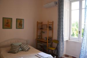 sypialnia z łóżkiem, oknem i krzesłem w obiekcie Casa Arcoiris w mieście Neapol