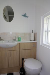 ein Badezimmer mit einer weißen Toilette und einem Waschbecken in der Unterkunft Saffron House in Fowey + 12 Fotos