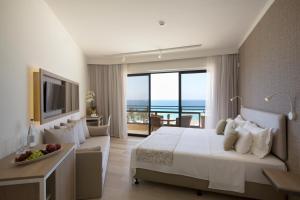a hotel room with a bed and a view of the ocean at Venus Beach Hotel in Paphos
