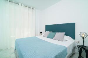 1 dormitorio con 1 cama grande y cabecero azul en Flatsforyou Ruzafa, en Valencia